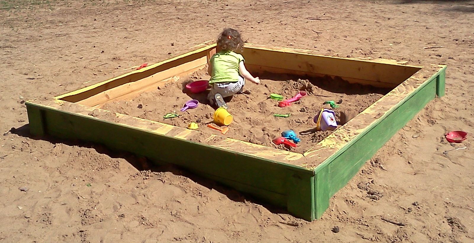 Jeune fille jouant dans un carré de sable