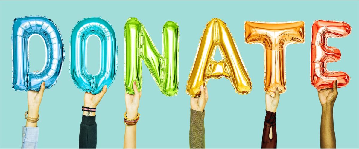 Personnes qui tiennent des ballons en forme de lettres qui forment le mot : DONATE